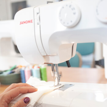 Guiding fabric through sewing machine.