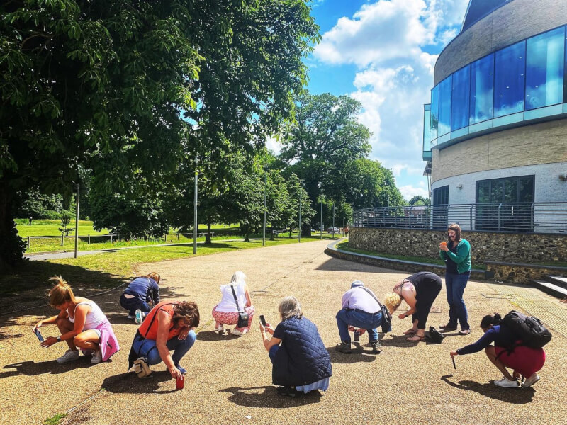Students at a photography class are taking pictures low down on the ground