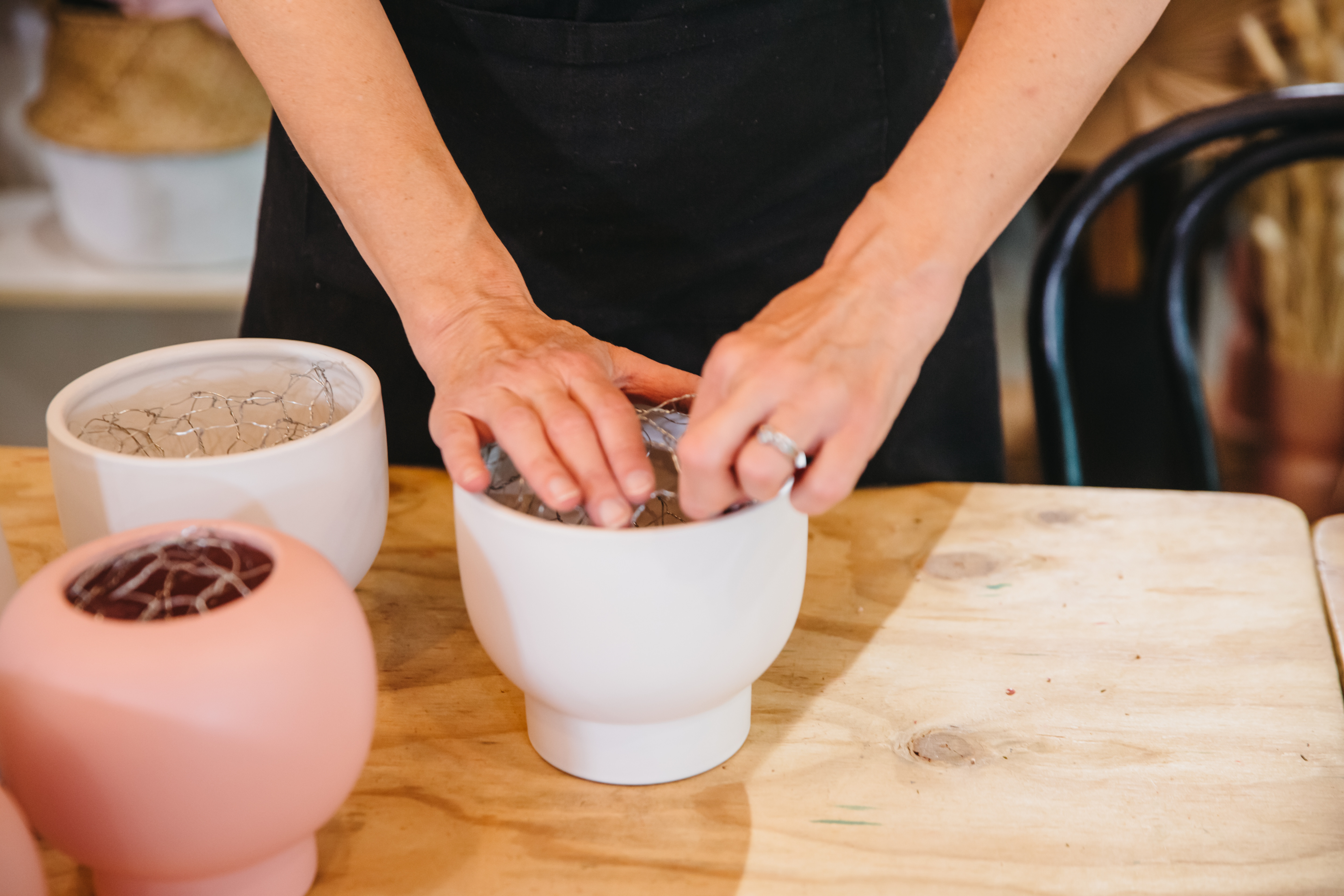 Person adding potting soil to a pot