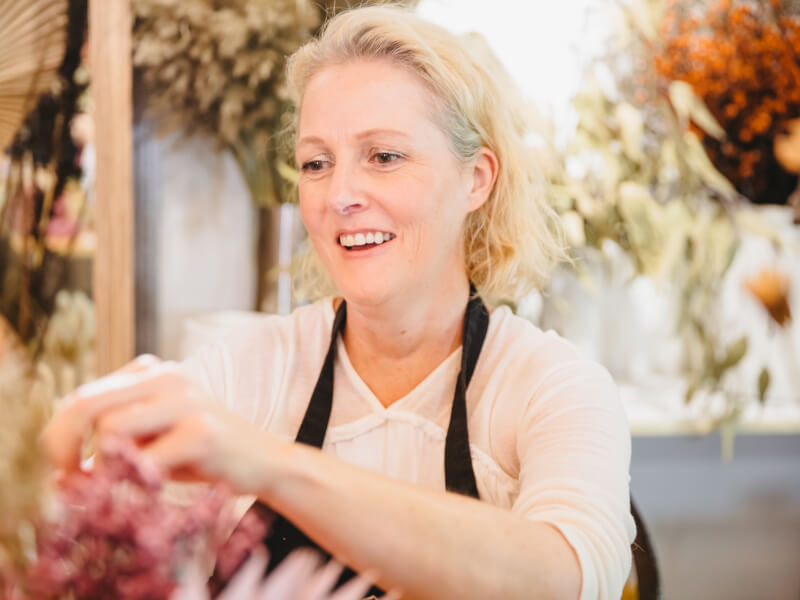 Woman smiling at a floristry class.