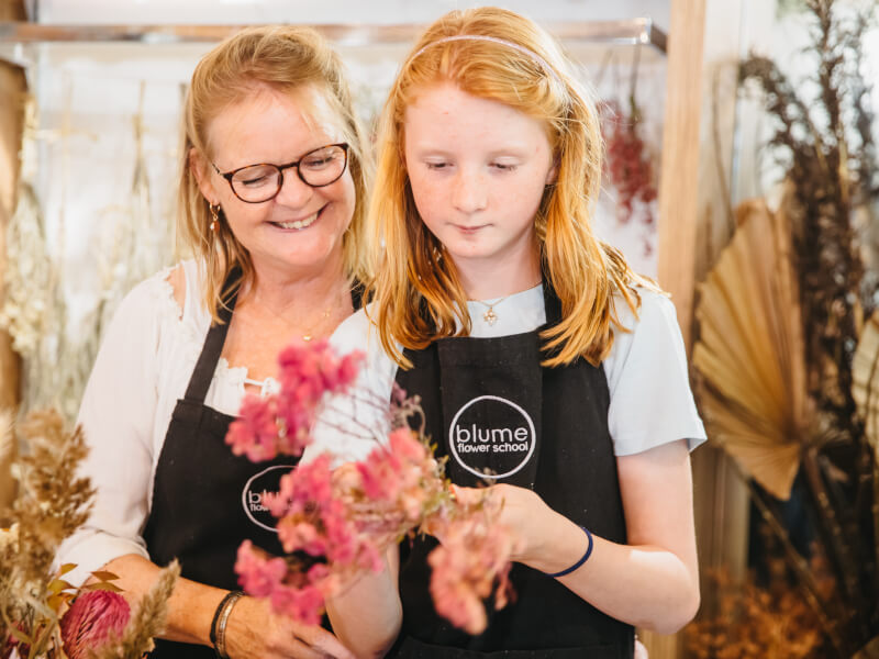 A mother helping her daughter at a flower arranging class