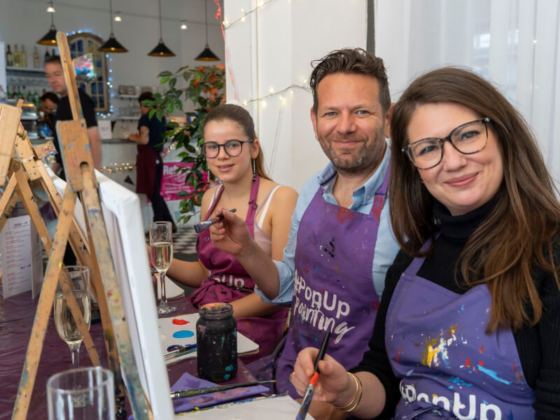 Three people smiling at a paint and sip class