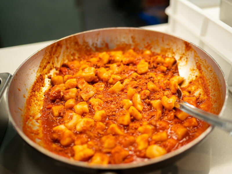 A frying pan full of gnocchi and sauce