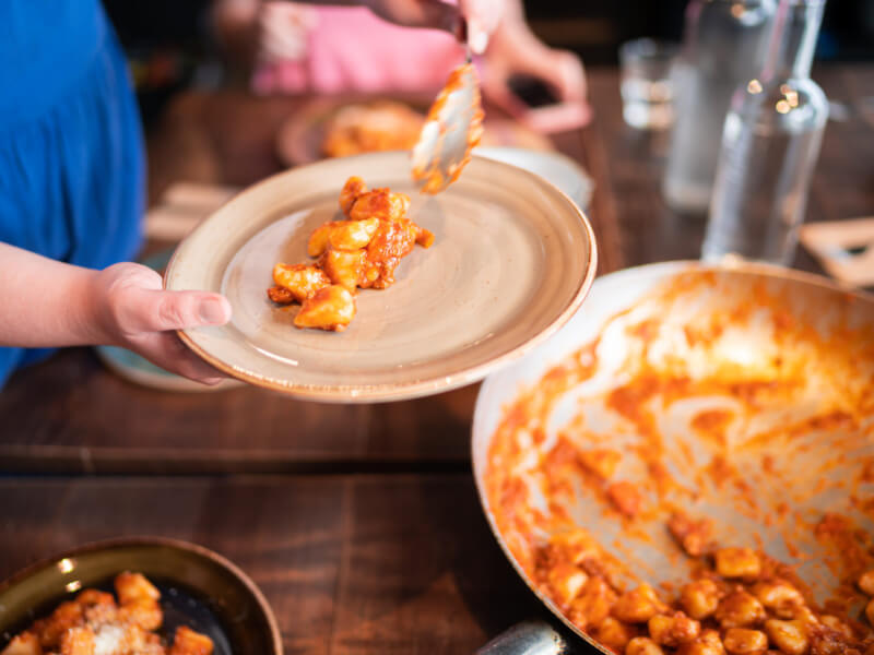 Homemade gnocchi being plated up in a cooking class.