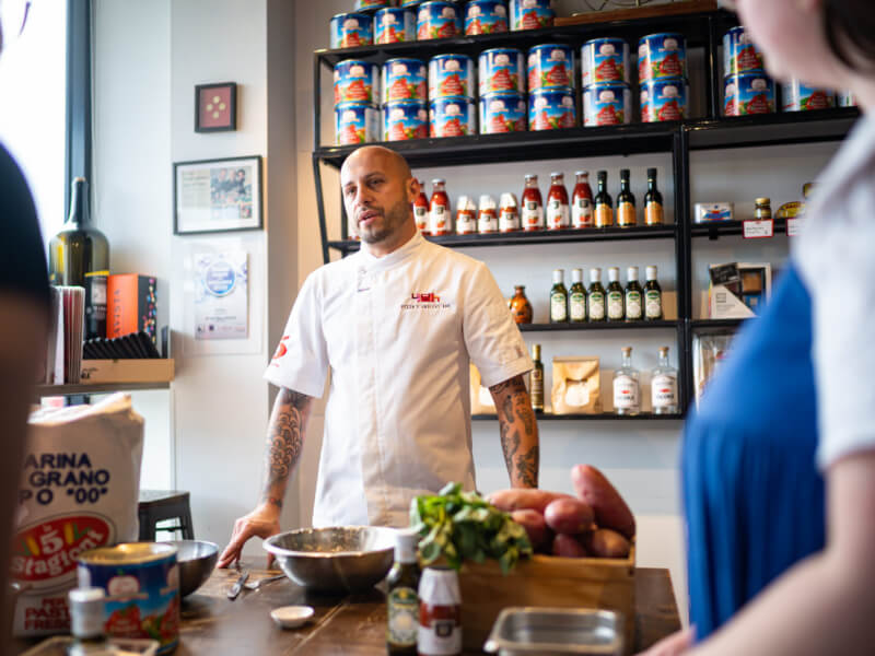 A man runs an Italian cooking class in a restaurant.