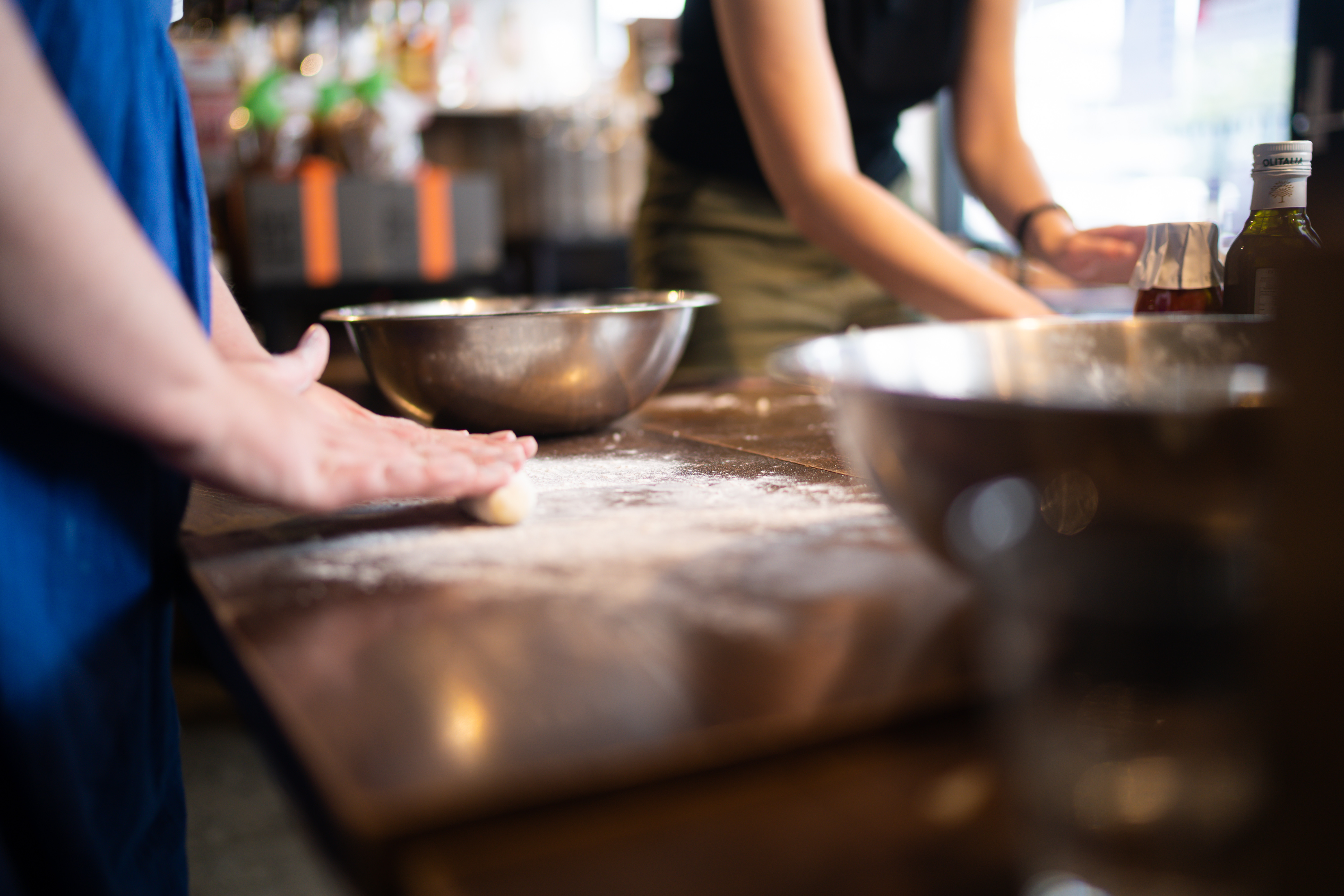 A group of cooking students rolling dough on boards