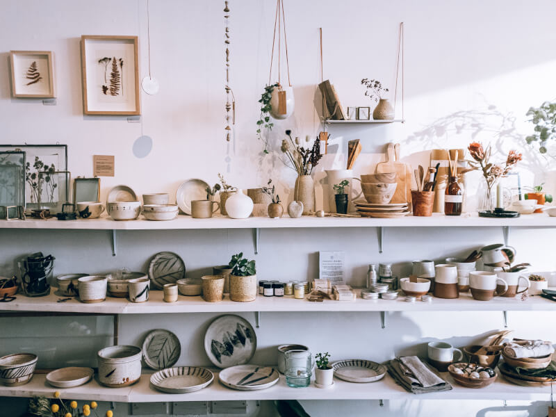 Several shelves filled with homemade pottery items