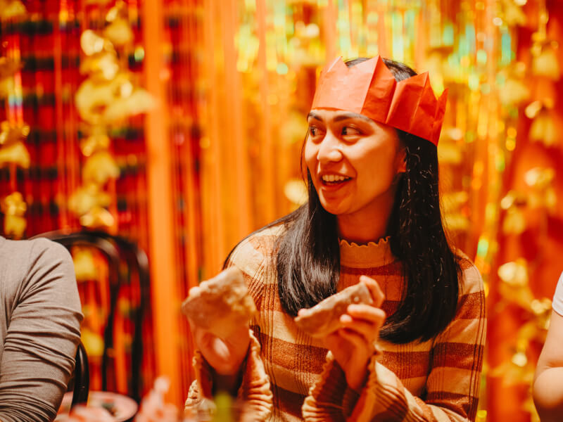 A woman in a party hat enjoying the festive atmopshere