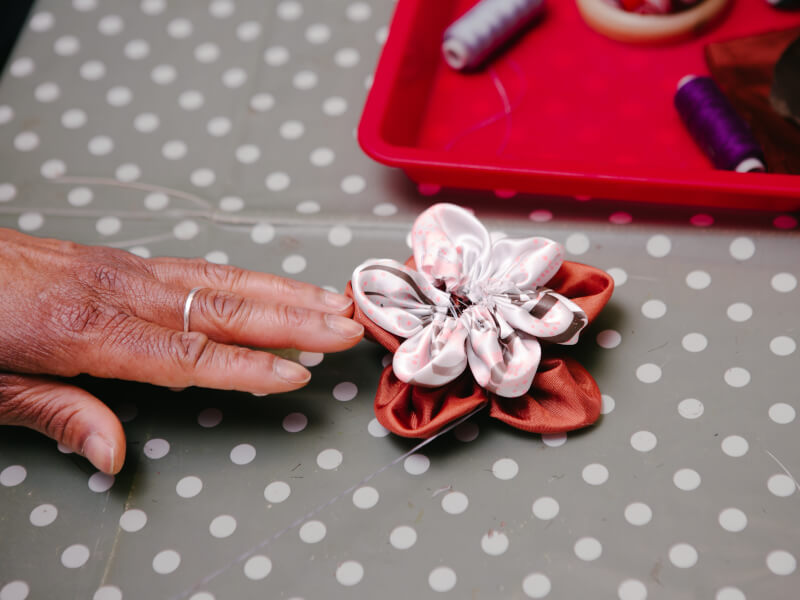 Close up of a colourful scrunchie sitting on a polka dot table cloth