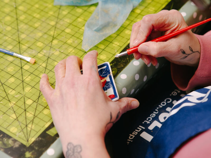 Close up of a person using a tool to finish a piece of kintsugi pottery