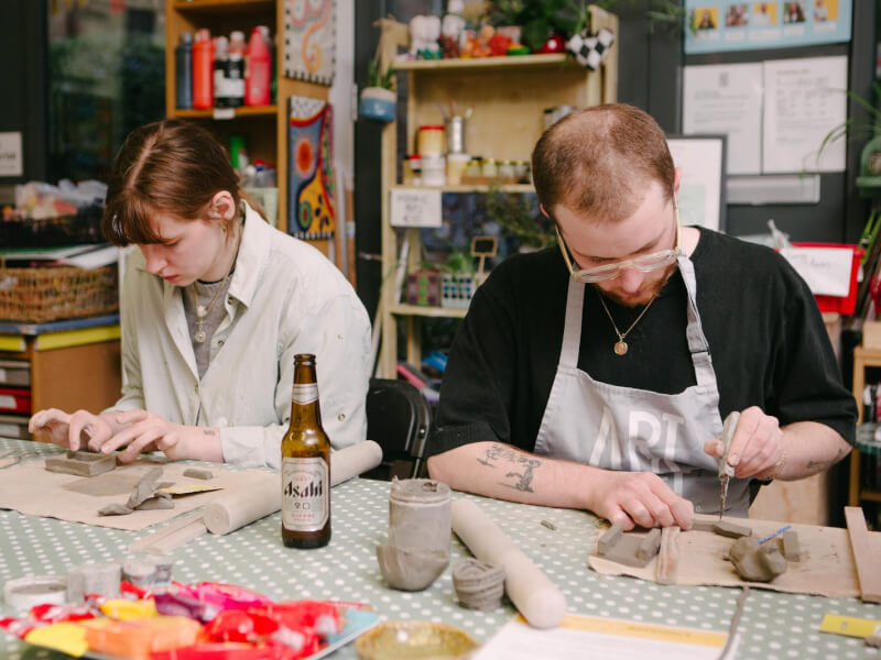 Two people at a sculpt and sip pottery class