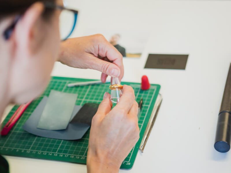 A person measures their handmade ring.