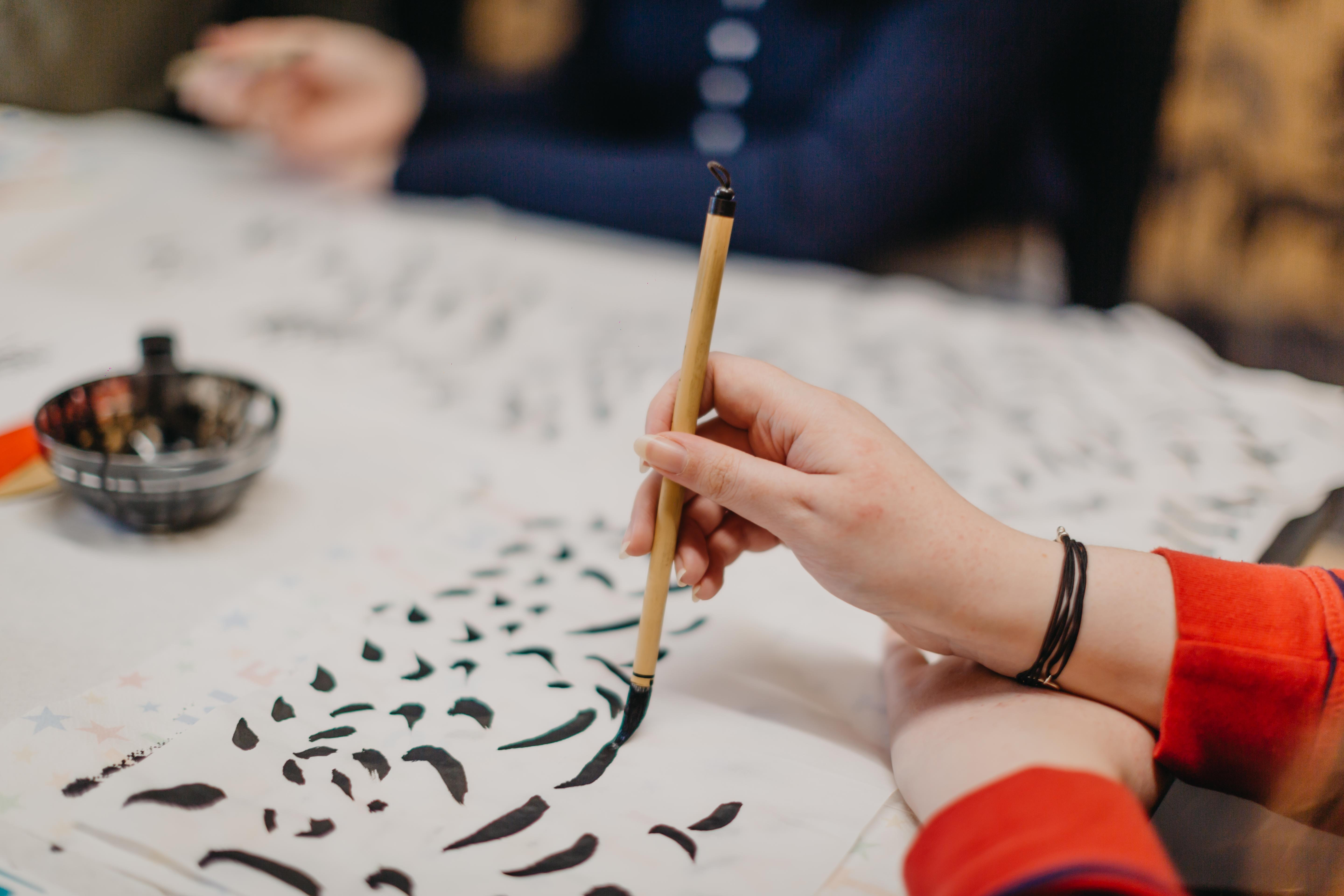 Close up of someone practicing calligraphy strokes