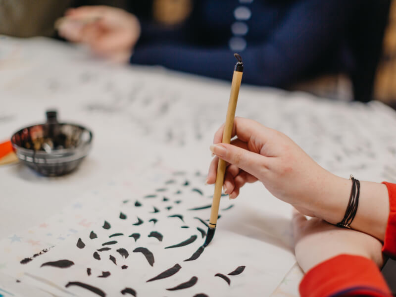 Close up of a hand learning brush lettering in a class.