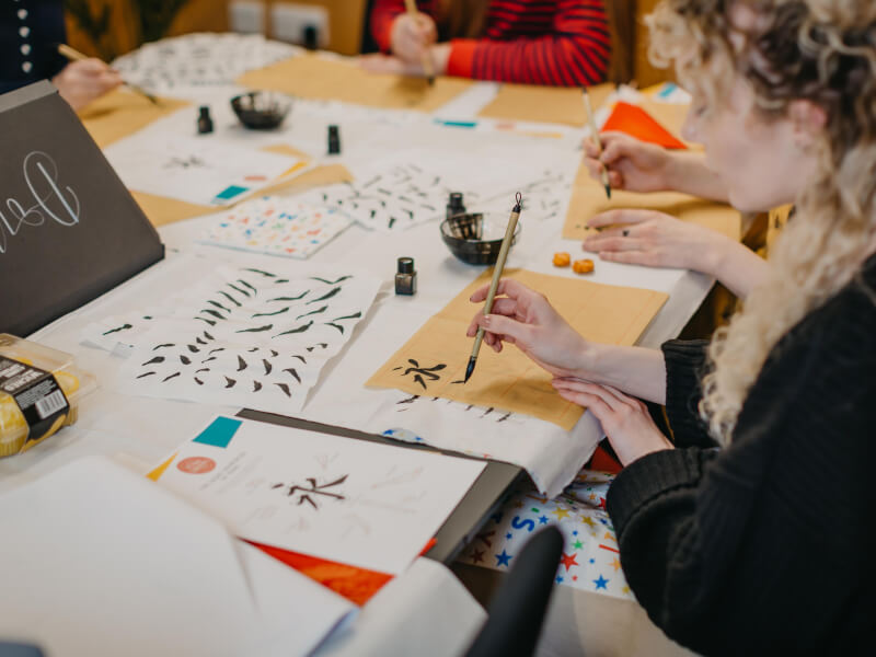Close up of a woman doing some hand lettering with a brush