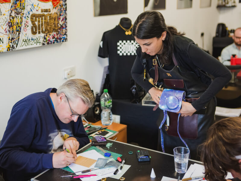Two people are making jewellery with a selection of crafters tools