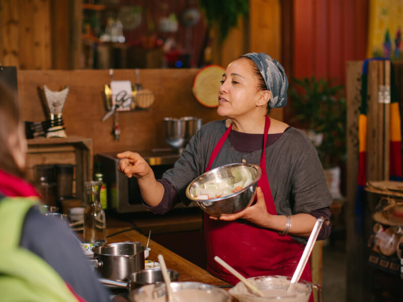 A teacher instructs her students at a cooking class