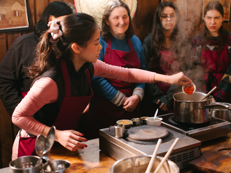 A group of students watching their teacher at a cooking class