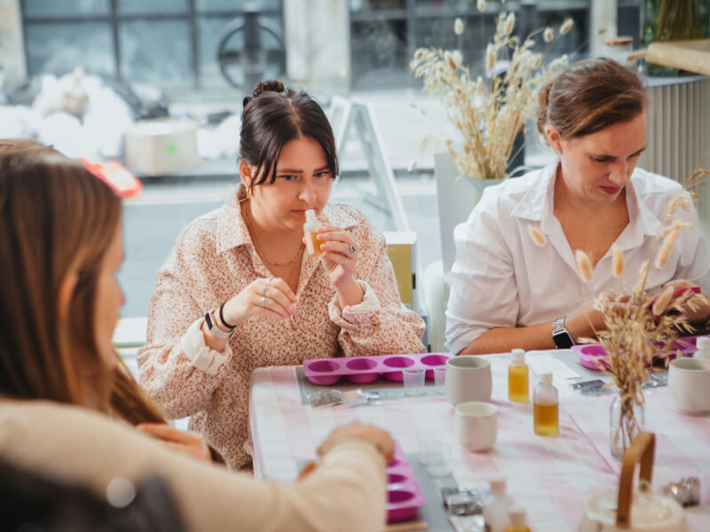 A woman at a soap making class smells a bottle of essential oil