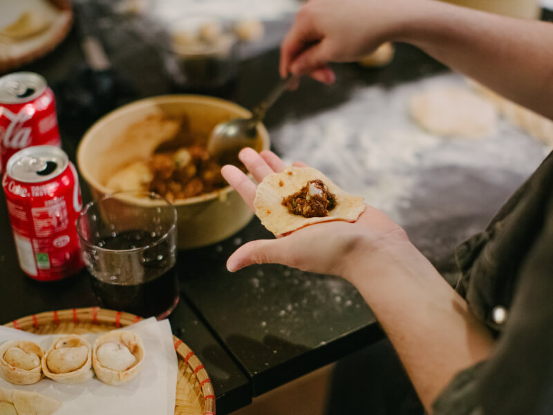 A hand holding a dumpling at a cooking class in Bath