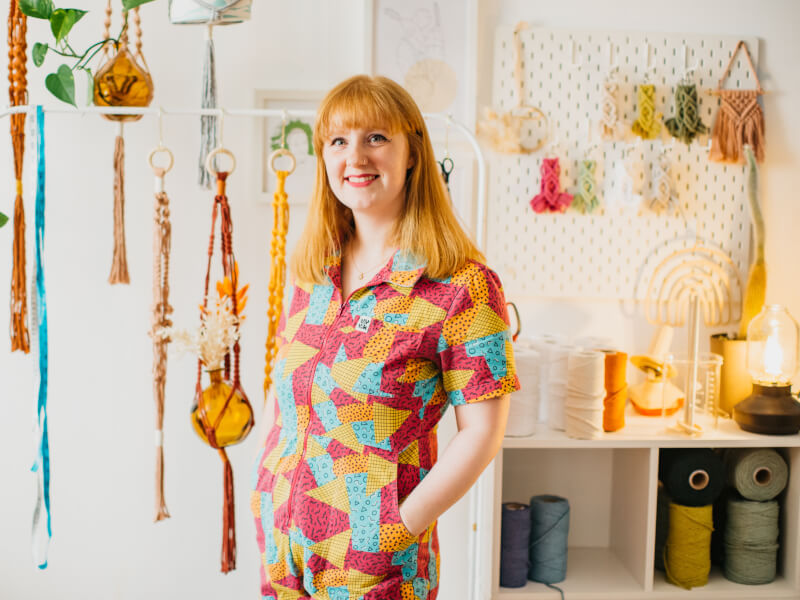 Chelsie Southern in her studio, surrounded by handmade macrame planters and wall hangings