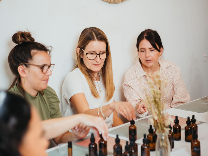 Three women at a hen party making beauty products together