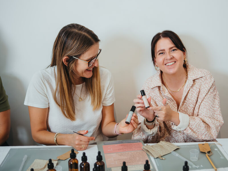 Two women smiling at a perfume making class