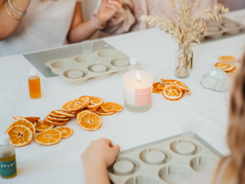 A table in a Christmas candle making class with oranges.