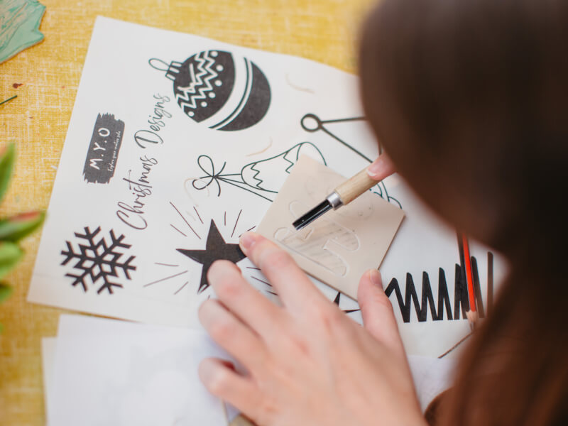 Close up of a person using stencils to make a Christmas themed print