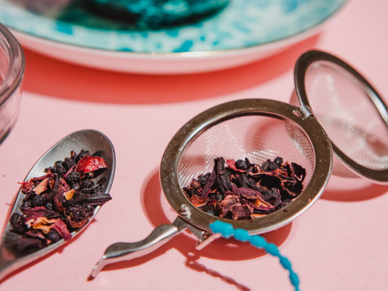 A mesh tea strainer filled with loose leaf tea