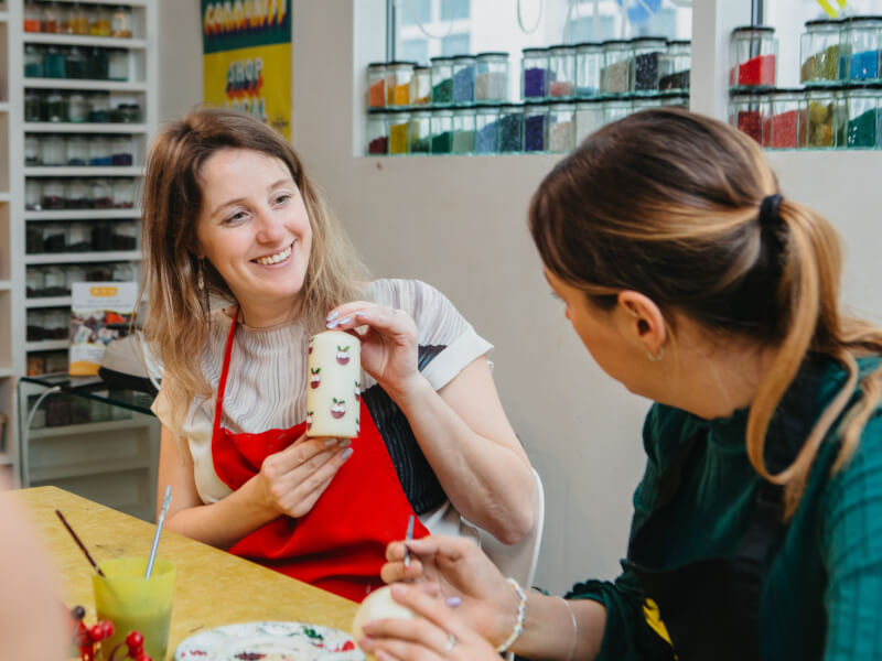 Two people at a festive candle painting class