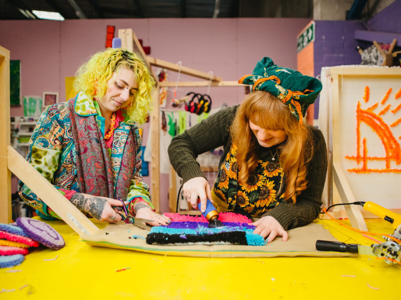 Alena Ruth of Manchester Tufting teaching a student how to finish a handmade rug