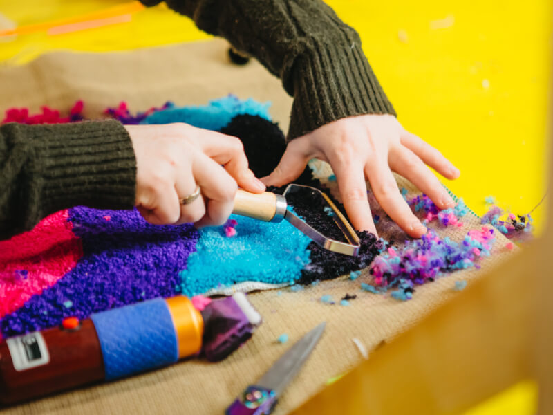 Close up of a person shaving their tufting project