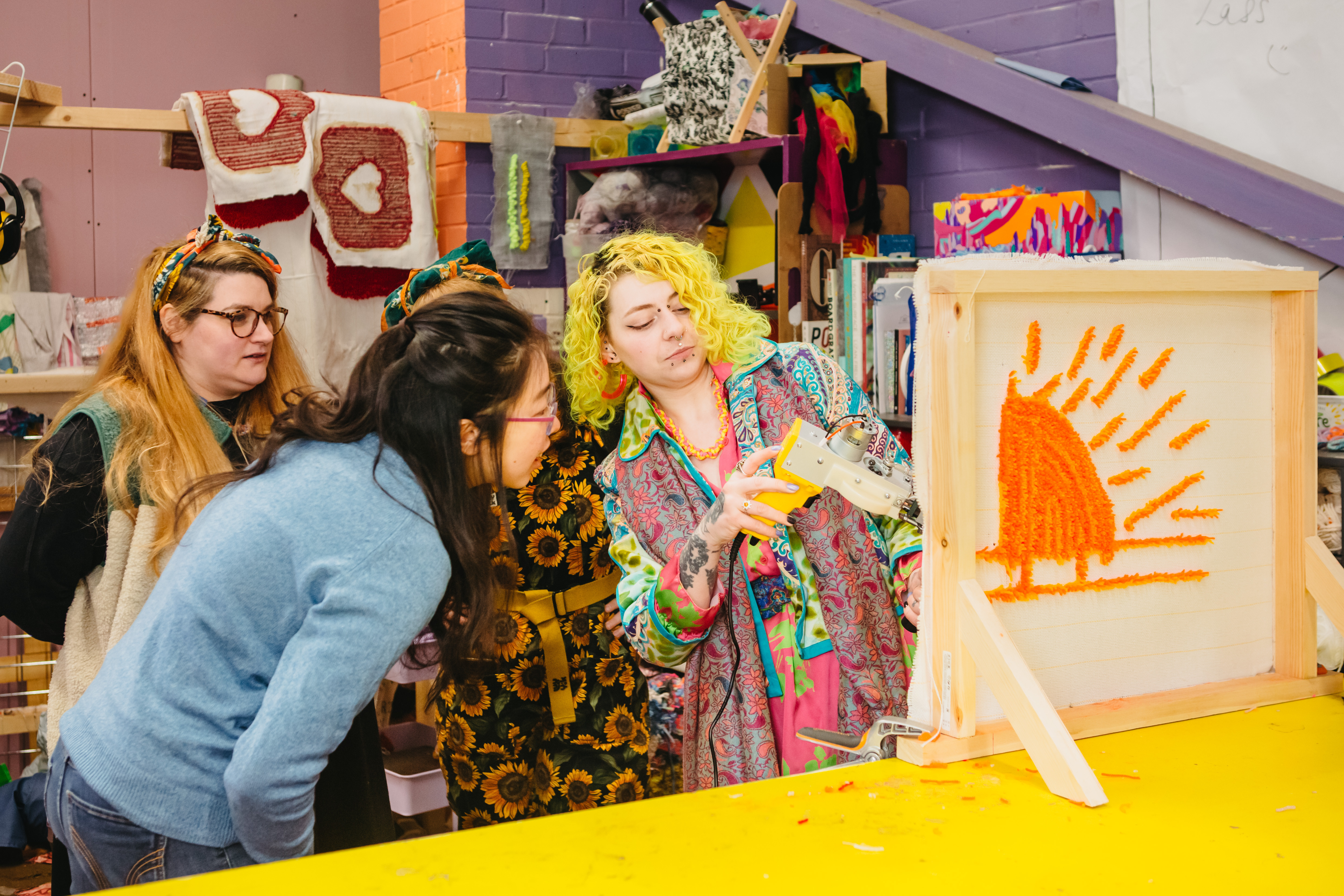 A group of people at a tufting class