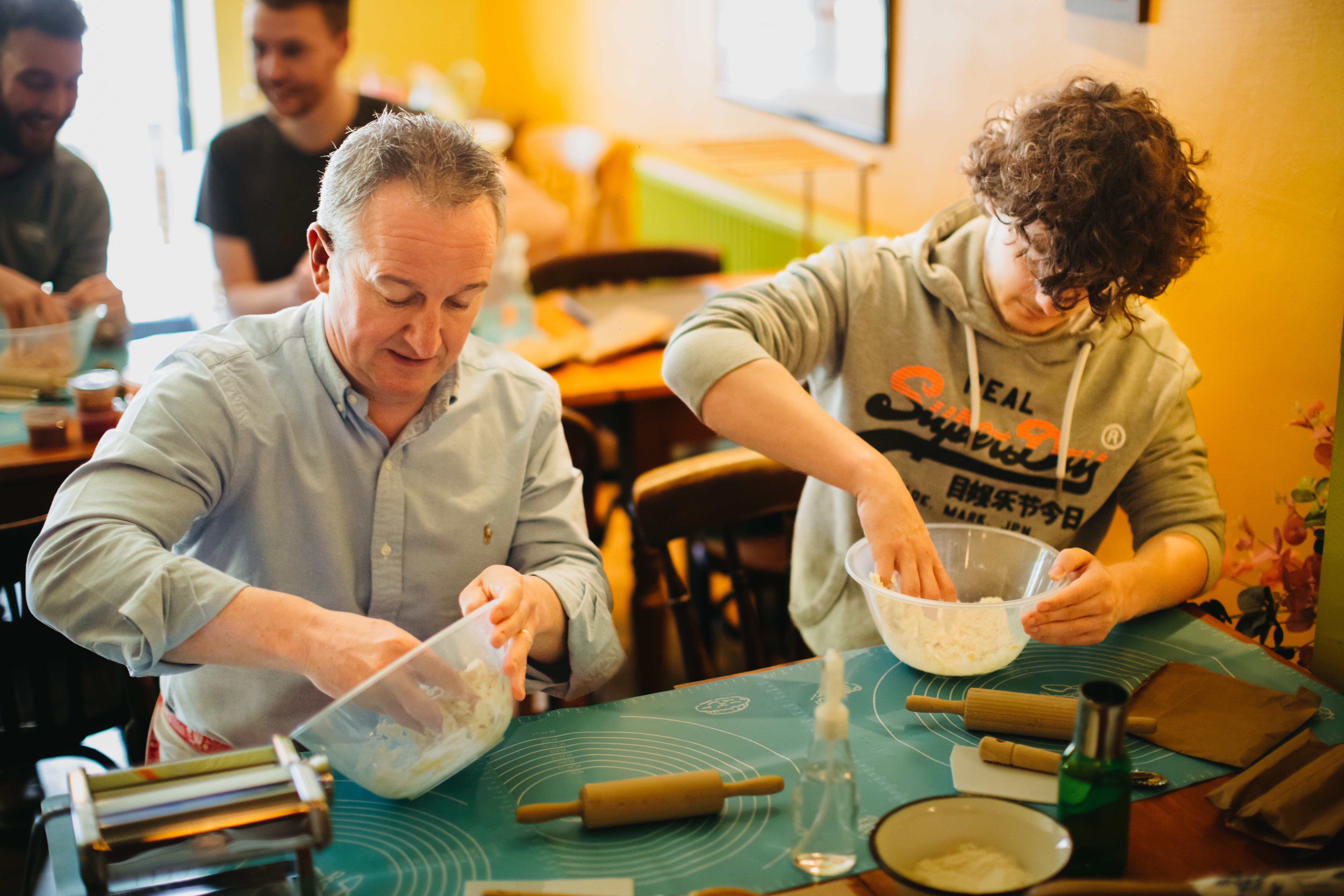 Two people mixing food by hand at a cooking class
