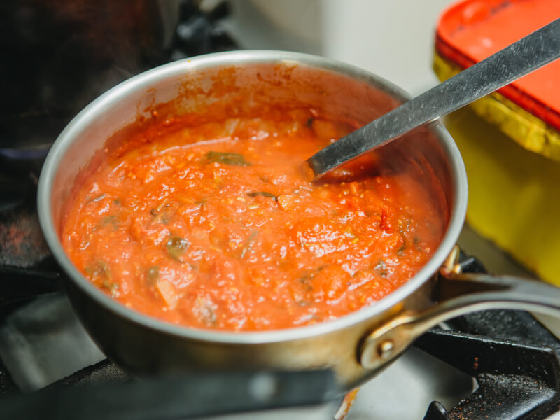 Stirring a pot of pasta sauce