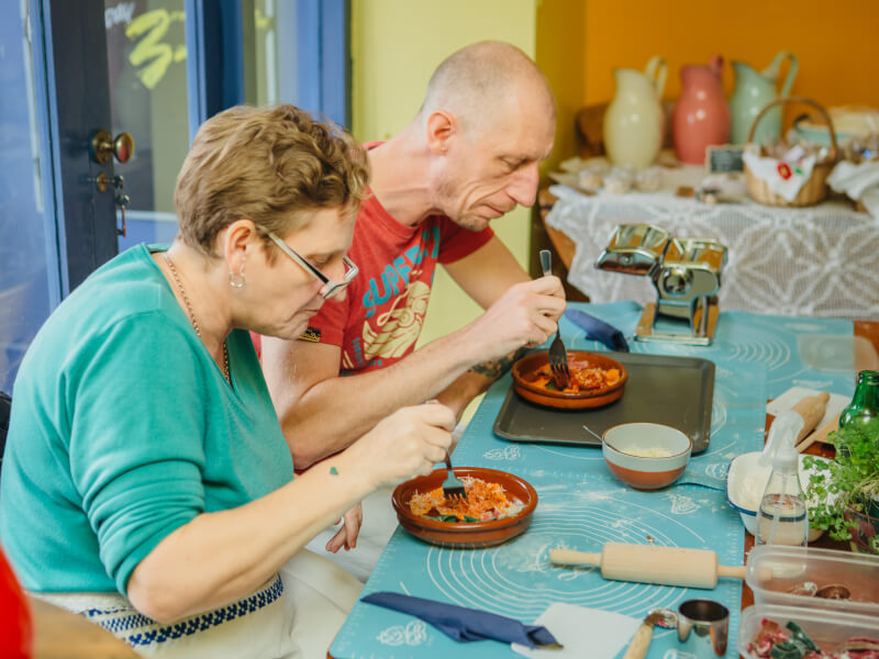 Two people sitting at a table eating the food they've made at a cooking class