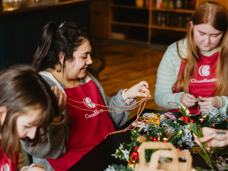 A group of women making Christmas themed macrame decorations