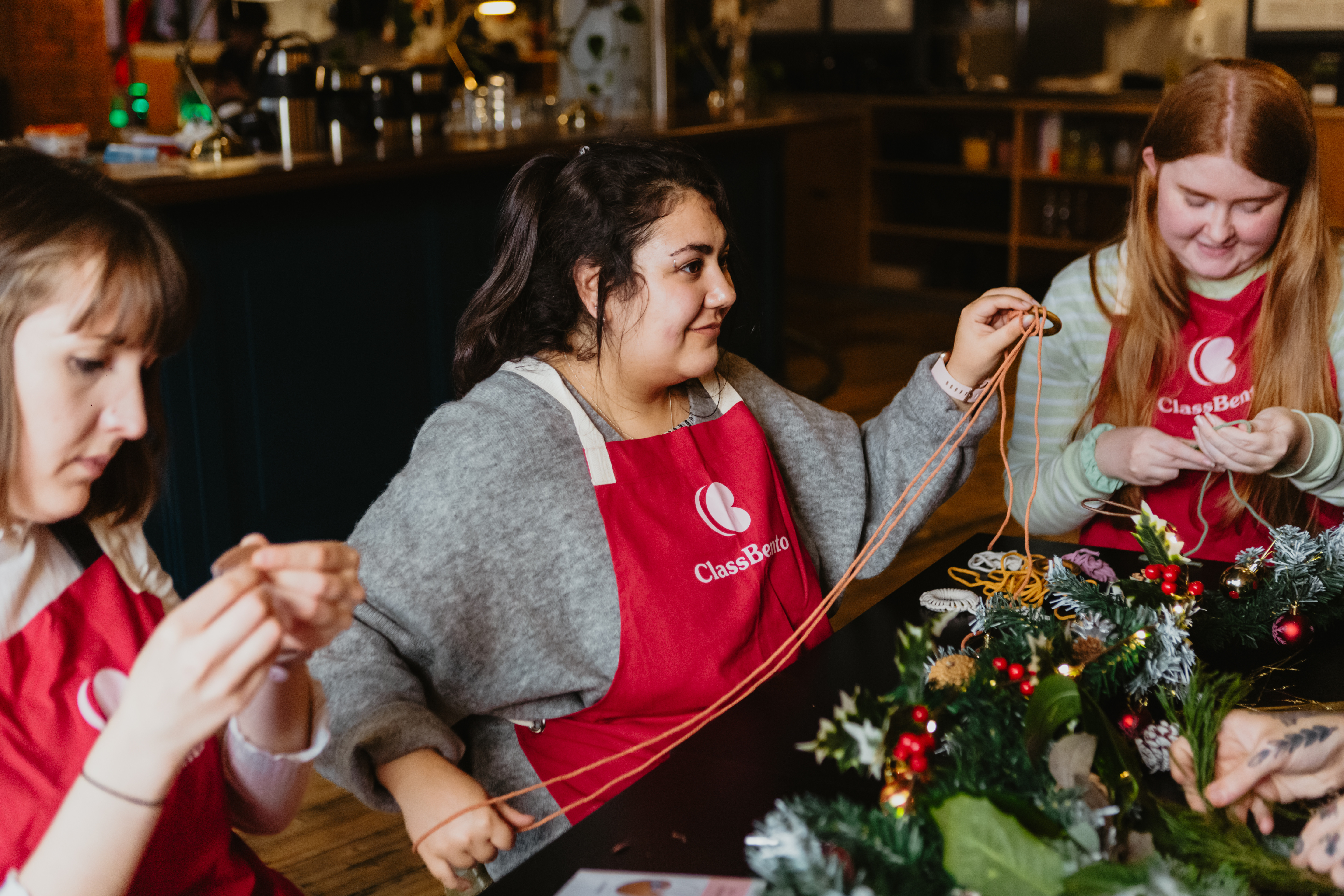 A group of women working on Christmas themed macrame