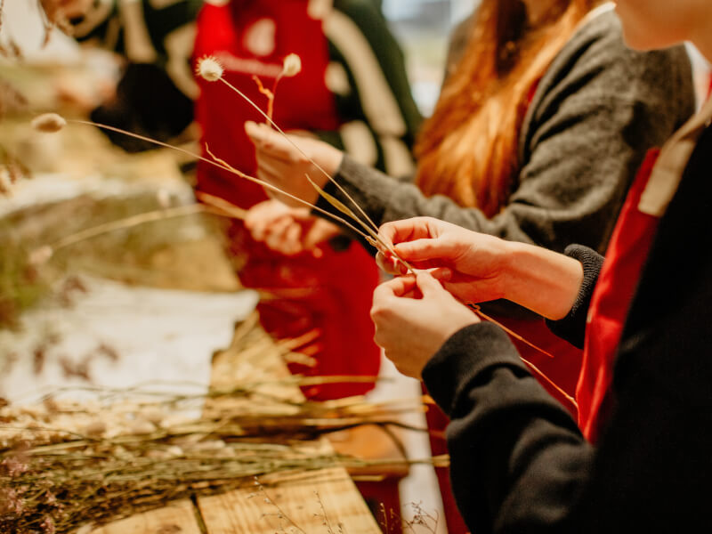 Close up of people arranging dried flowers