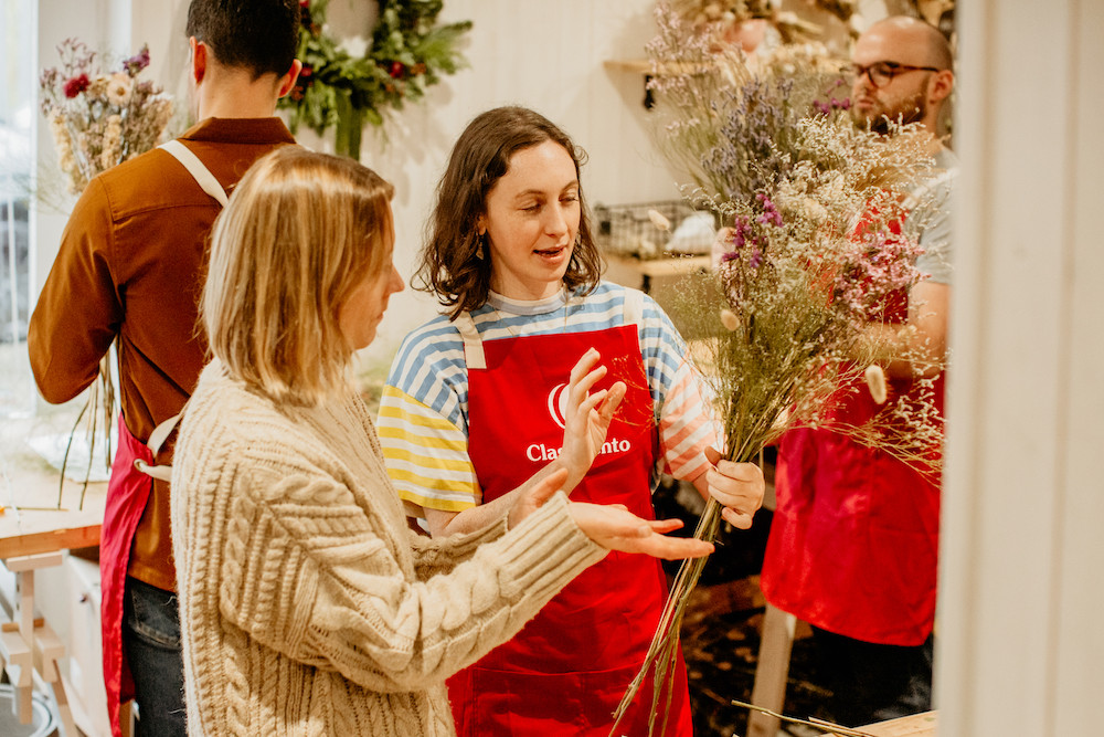 A teacher explains how to make a dried flower arrangement at a floristry class