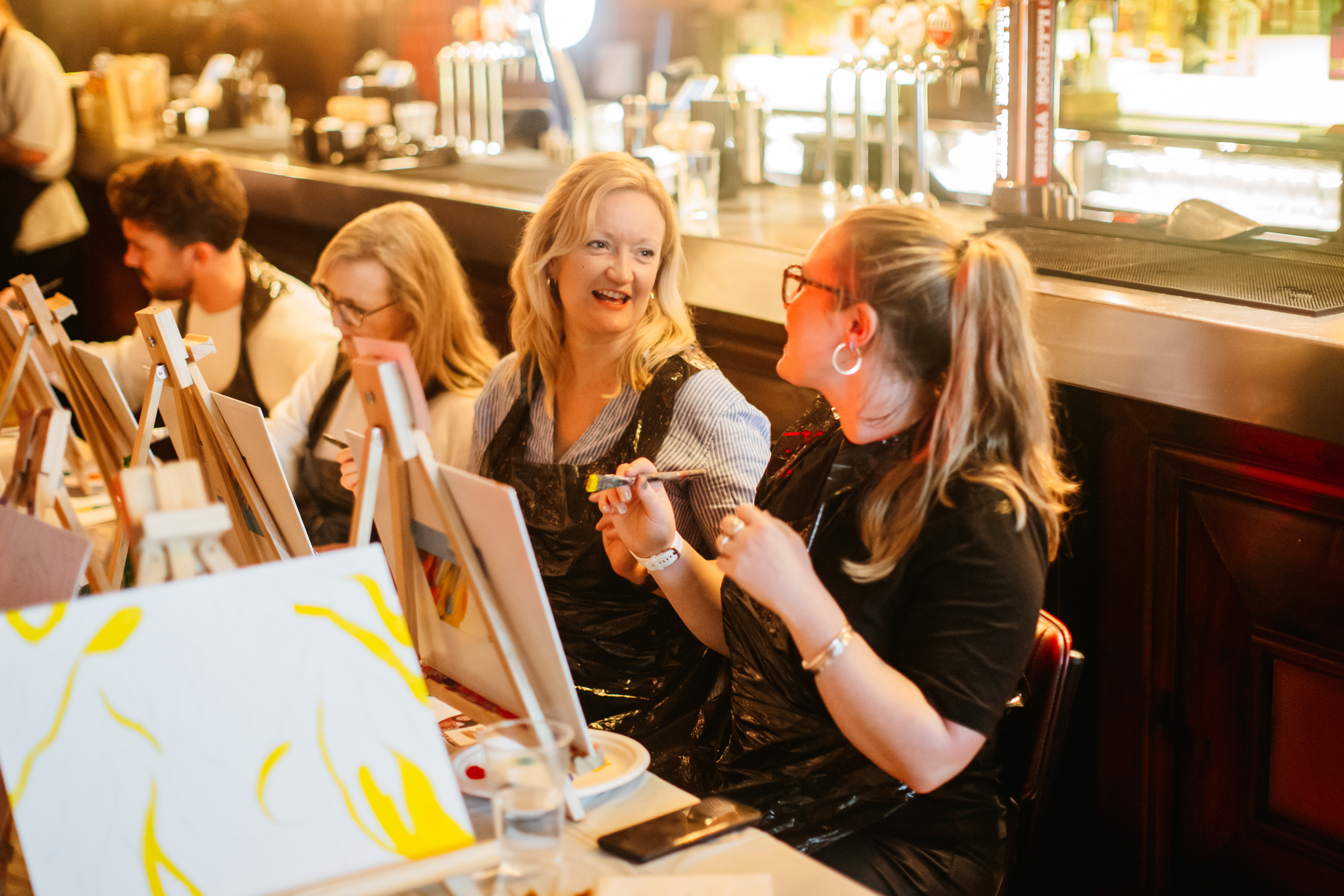 A group of women enjoying a hen party painting class
