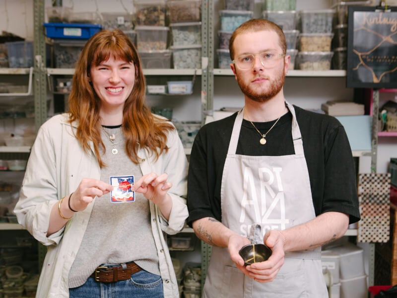 A couple holding pottery at a craft class