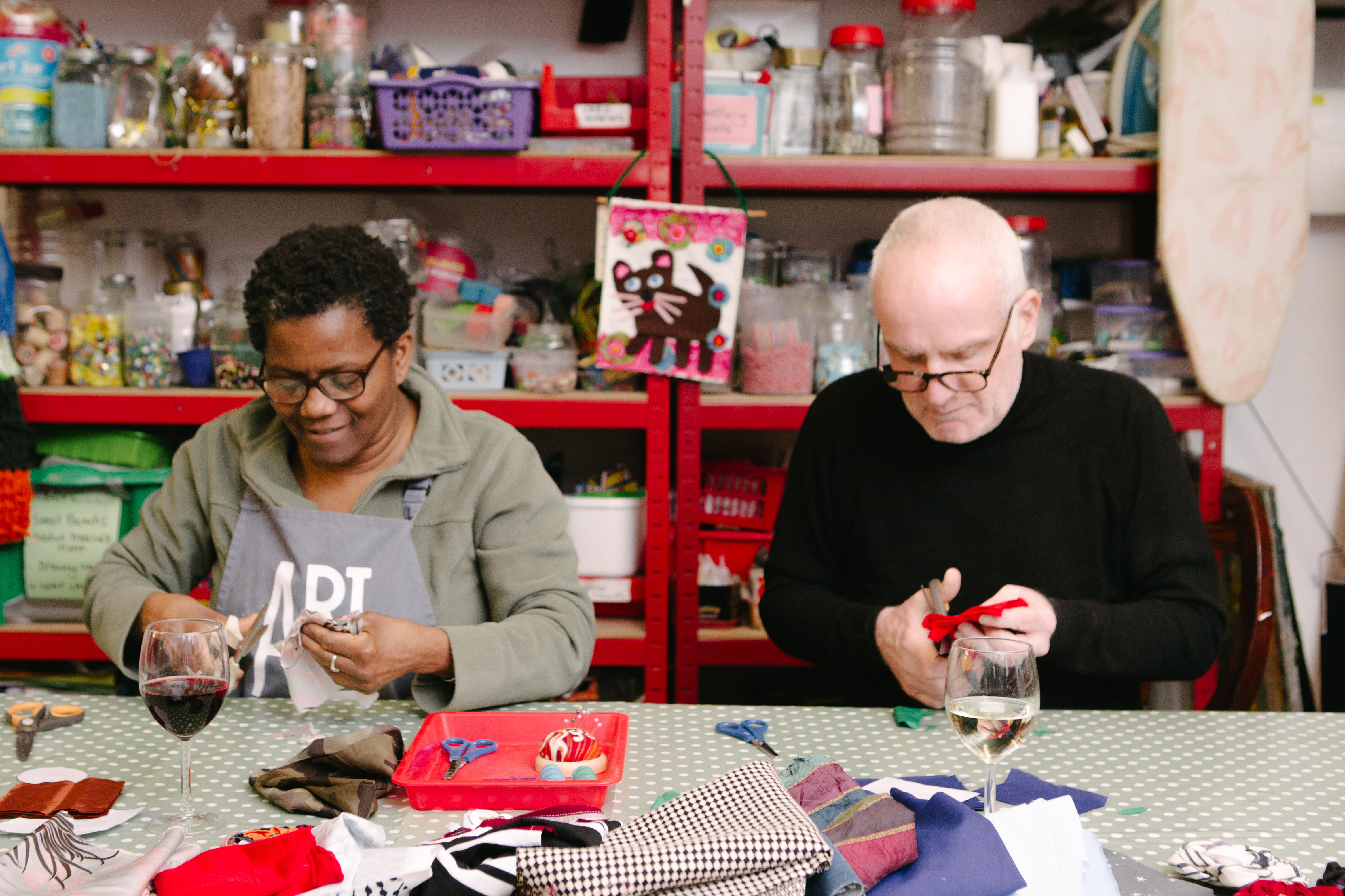 A man and woman making fabric flowers at a sewing class