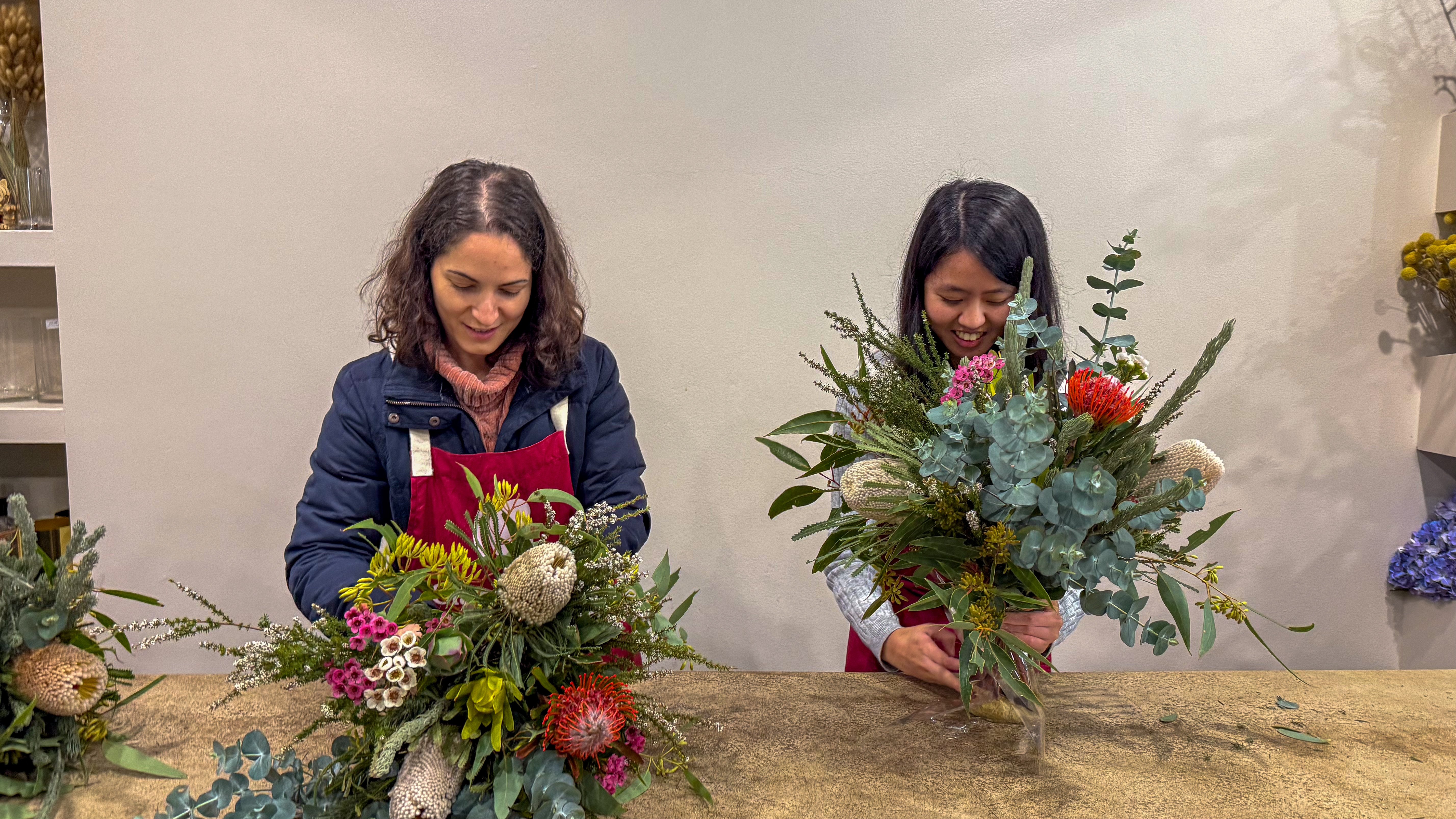 Two people making flower arrangements at a floristry class