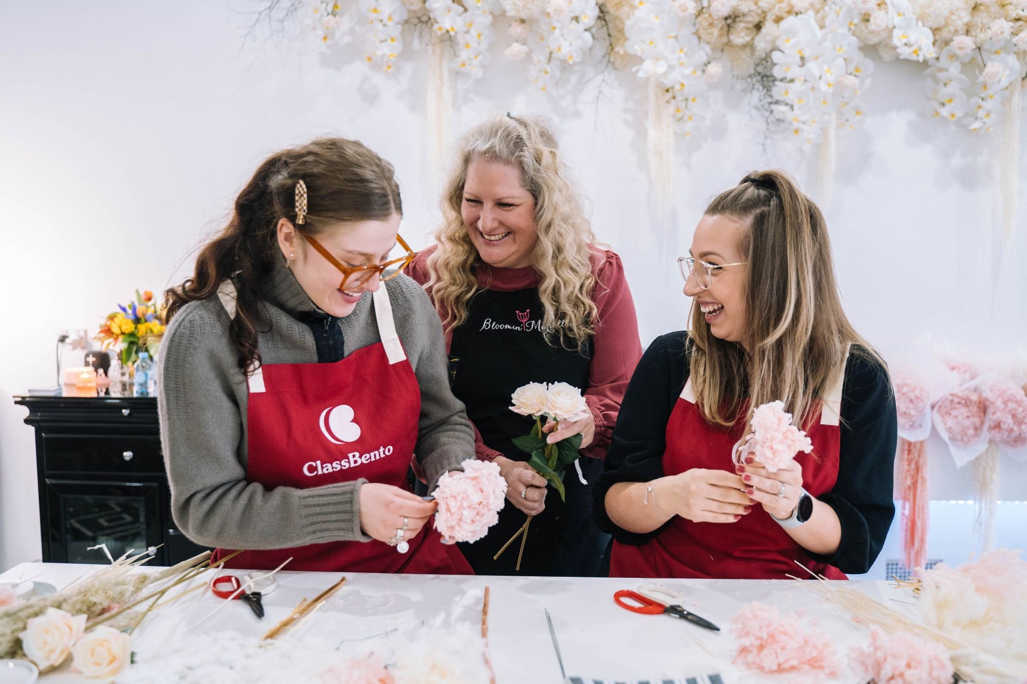 A couple learning from their teacher at a floristry class