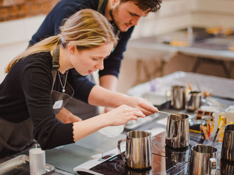 Two students work at a candle making class