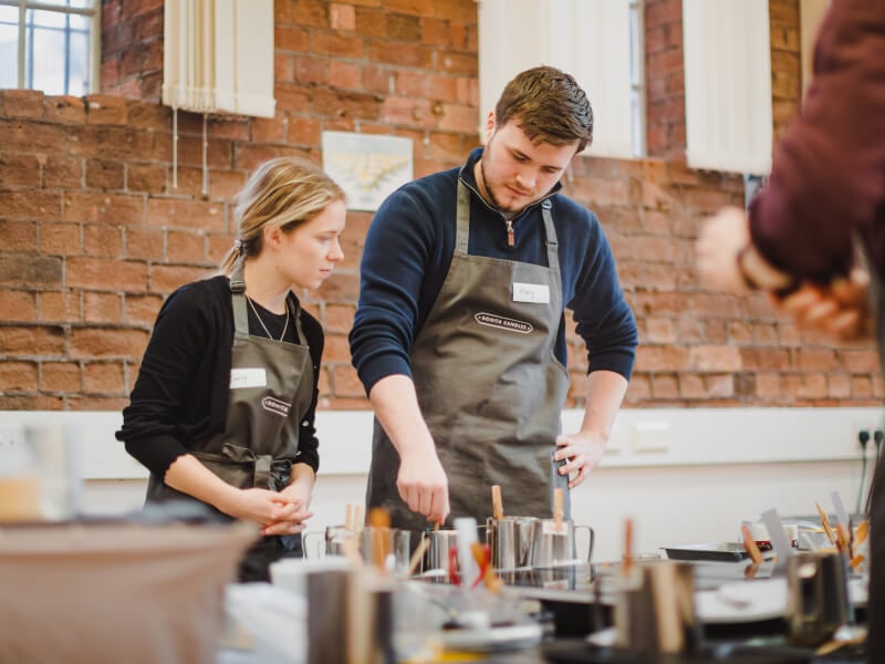 Two students creating candles at a candle workshop