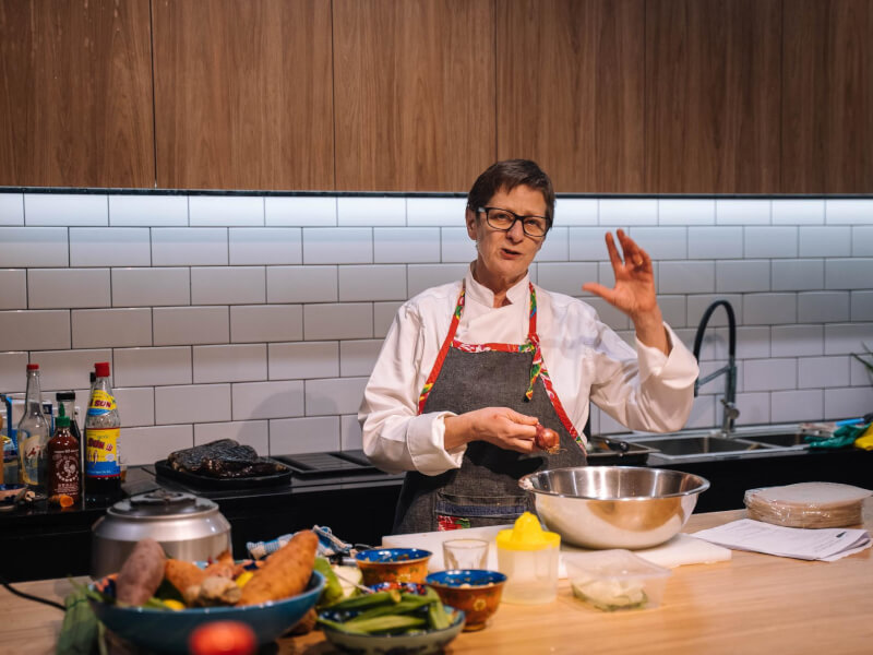 A chef explaining a dish to a cooking class