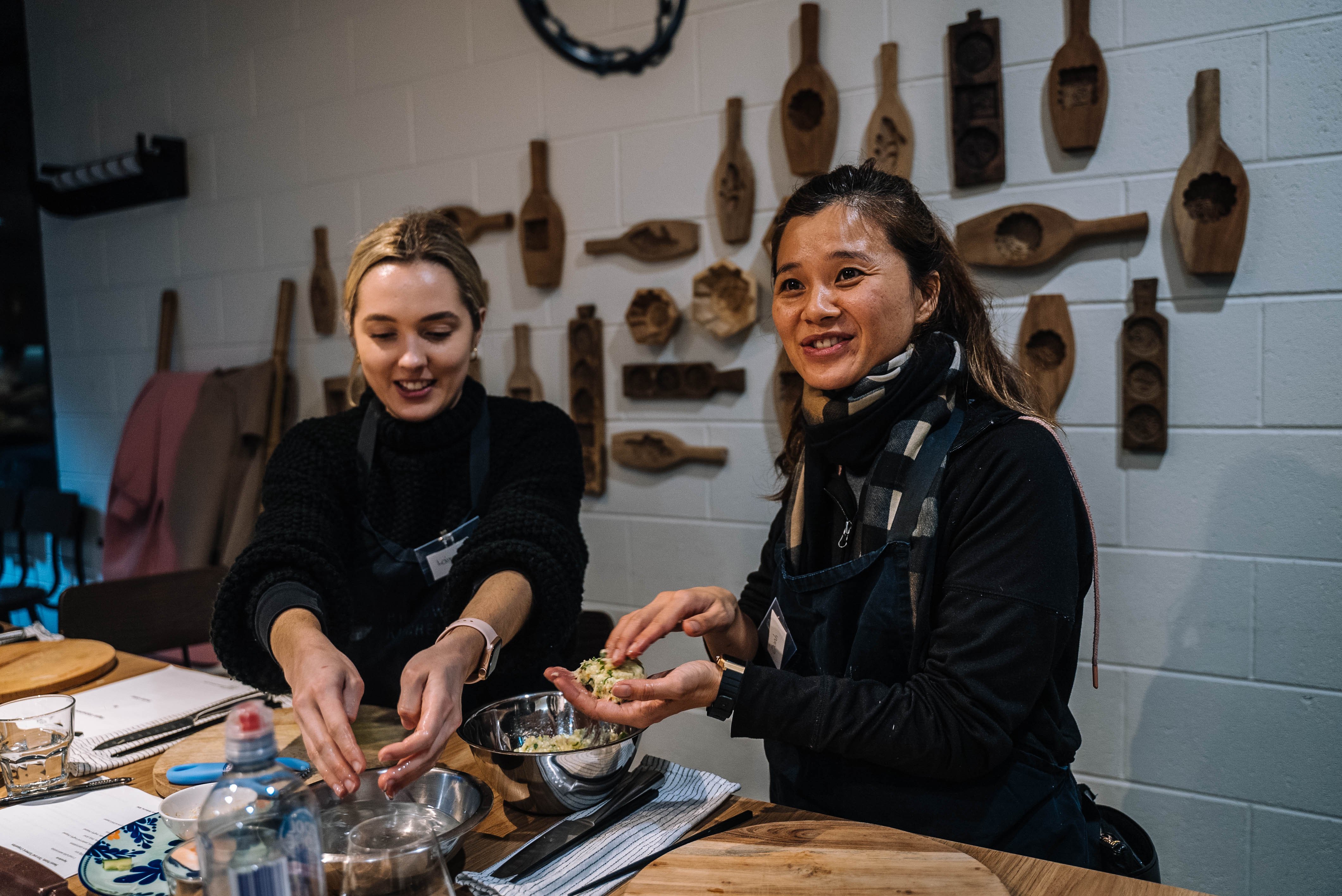 Two people preparing a vegan dish in metal bowls